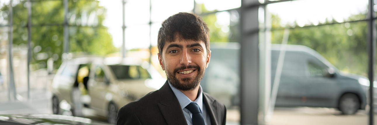 A headshot of Jay Simpson in a car showroom